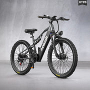 A black Xiongshik electric fat-tire bicycle shown from a three-quarter front angle against a textured gray studio background. The bike features a matte black frame with the brand name 'XIONGSHIK' printed on the downtube, knobby tires, a front suspension fork, and a rear battery pack.