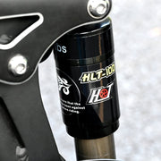 Close-up of a bike suspension fork with 'HIT' branding on a blurred background