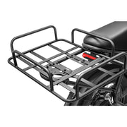 A black metal luggage rack mounted behind the seat and wheel of a motorcycle, shown on a clean white background.