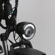 Close-up of a bicycle headlight with visible brand logo on a gray background