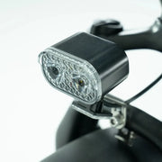 Bicycle light attached to a handlebar with a white background