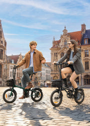 Two people riding electric bikes on a cobblestone street with historic buildings in the background.